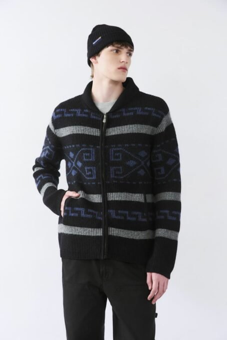 Cardigan tejido jaquard con dibujo fantasía. Cuello alto. Apertura con cierre niquel. Bolsillos laterales. Galga 5 (pesado). Composición 80% lana 20% poliamida. Hecho en India.