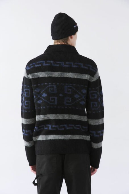 Cardigan tejido jaquard con dibujo fantasía. Cuello alto. Apertura con cierre niquel. Bolsillos laterales. Galga 5 (pesado). Composición 80% lana 20% poliamida. Hecho en India.
