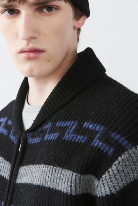 Cardigan tejido jaquard con dibujo fantasía. Cuello alto. Apertura con cierre niquel. Bolsillos laterales. Galga 5 (pesado). Composición 80% lana 20% poliamida. Hecho en India.