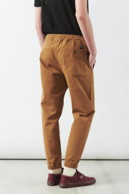 Pantalón con cintura con elástico embutido y cordón. Puños con elástico. Botones marmolados. Composición: Gabardina 98% algodón 2% elastano. Hecho en Argentina.