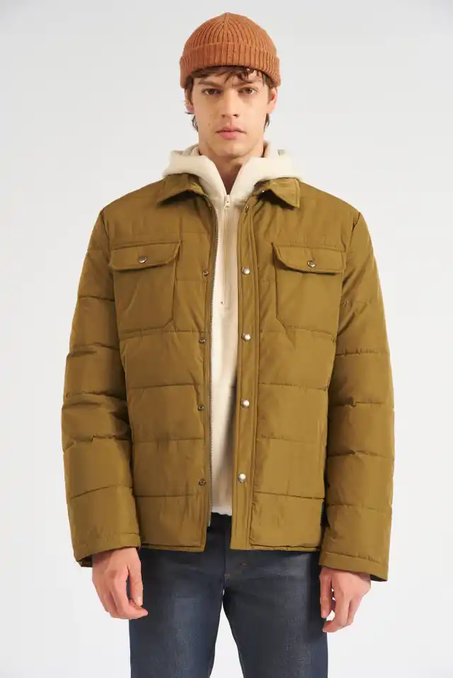 Campera con relleno soft de calce regular con cuello. Cierre escondido niquel, con cartera y broches. Dos bolsillos plaque en el frente con tapa y broches, y dos bolsillos laterales. Etiqueta de goma al tono. Composición: 100% poliester. Relleno: 100% poliester. Hecho en China.